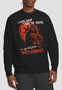 Black sweatshirt featuring a graphic of a character with orange accents. Text reads, "I find your lack of faith in my dad jokes DISTURBING!"