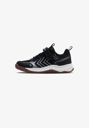 Zapatilla deportiva negra y gris con rayas blancas en zigzag, cierre de velcro y suela marrón antideslizante, vista de lado sobre fondo blanco.