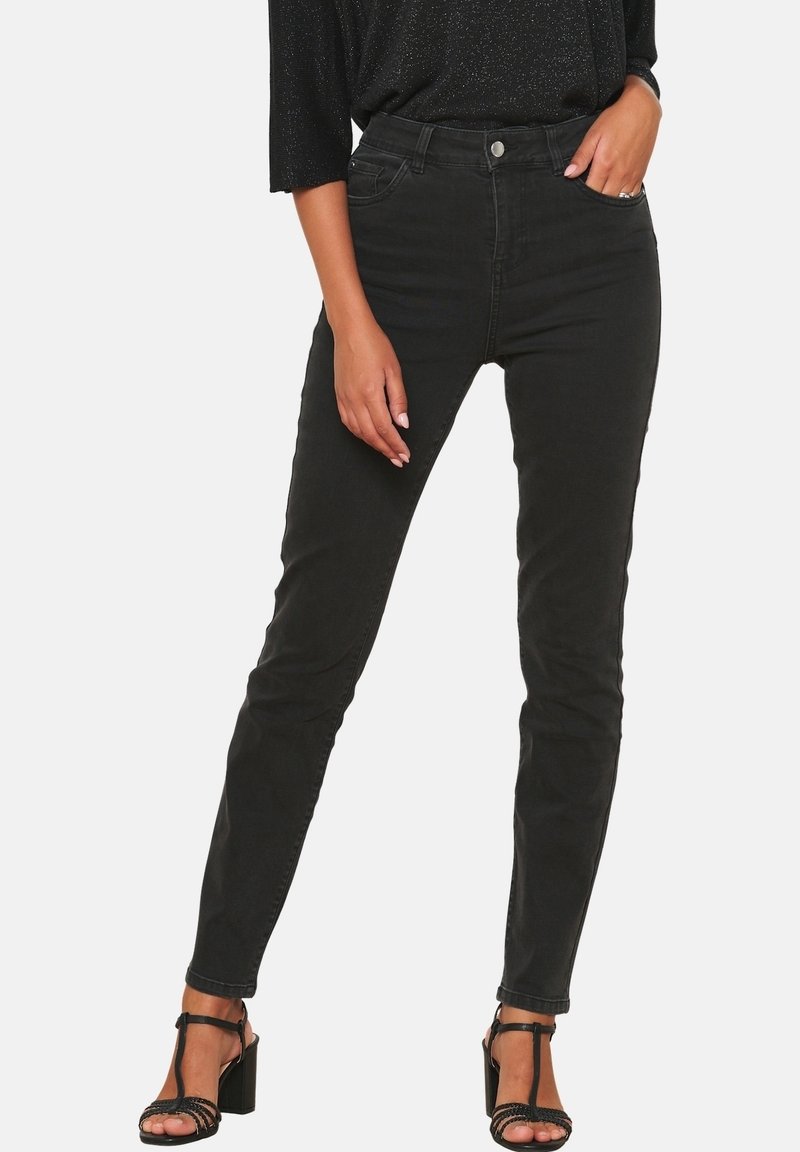 Svarta skinny jeans i denim, med hög midja, femfickorsdesign och smal passform, tillsammans med svarta sandaletter med remmar.