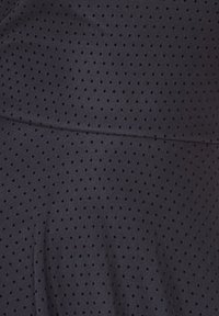 Musta kangas, jossa pieni pistekuvio koko pinnalla. Pinnassa näyttää olevan sileä rakenne ja kevyttä kiiltoa. Sauma kulkee vaakasuunnassa keskellä.