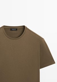 Oliven grøn kortærmet t-shirt lavet af blød bomuld, med rund halsudskæring og et mærke med mærkenavnet Massimo Dutti.