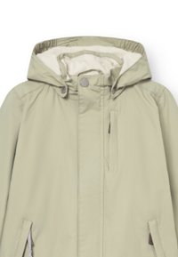 Veste vert clair avec capuche à cordon de serrage, fermeture éclair sur le devant, deux poches latérales et doublure douce couleur crème. Tissu lisse et résistant à l'eau.