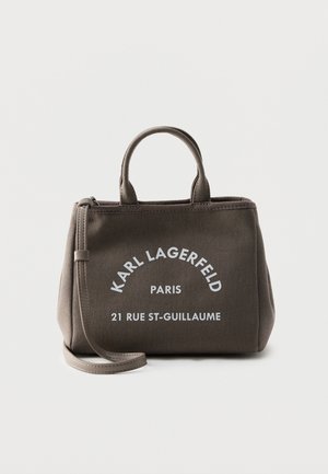 Väike hall ostukott lühikeste käepidemete ja eemaldatava rihmaga, valge tekstiga "KARL LAGERFELD PARIS 21 RUE ST-GUILLAUME" esiküljel.