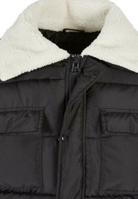 Sort puffjakke med en hvid faux shearling krave, lynlås lukning, to frontlommer og quiltet tekstur over hele jakken.