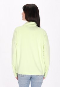Felpa verde menta con collo alto, maniche lunghe e vestibilità rilassata, realizzata in tessuto leggero e morbido.