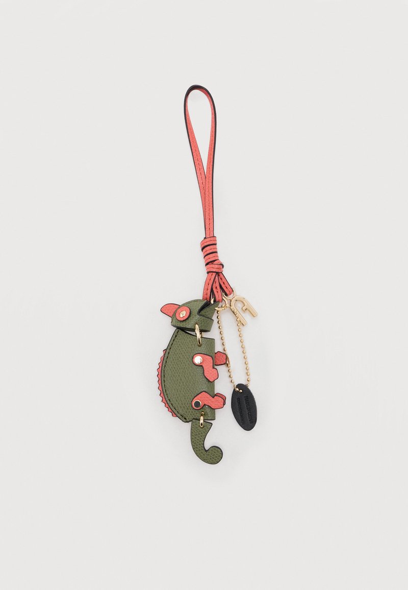 Πράσινο και κοραλλί δερμάτινο μπρελόκ σε σχήμα χαμαιλέοντα με κοραλλί λουράκι για τον καρπό, αλυσίδα σε χρυσό χρώμα και μαύρη οβάλ ετικέτα προσαρτημένη.