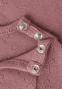 Neulottu vaatekappale malva-värissä, jossa on teksturoitu kuvio ja hopeiset painikkeet, vartissa olevat reunat sekä pehmeä, joustava kangas.