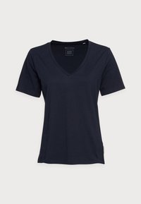 Námořnické tričko s výstřihem do V vyrobené z měkké bavlněné tkaniny, krátké rukávy a malý logo štítek na boku. Minimalistický design, klasický střih.