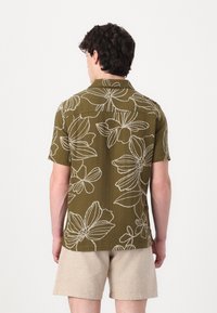 Short-sleeve shirt in olive green with white floral embroidery, featuring a collared neckline and a relaxed fit. Designed with a textured fabric.
