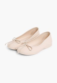 Ballerines beiges en tissu, avec un bout rond et un nœud décoratif à l'avant. Texture lisse, légères et au design discret.