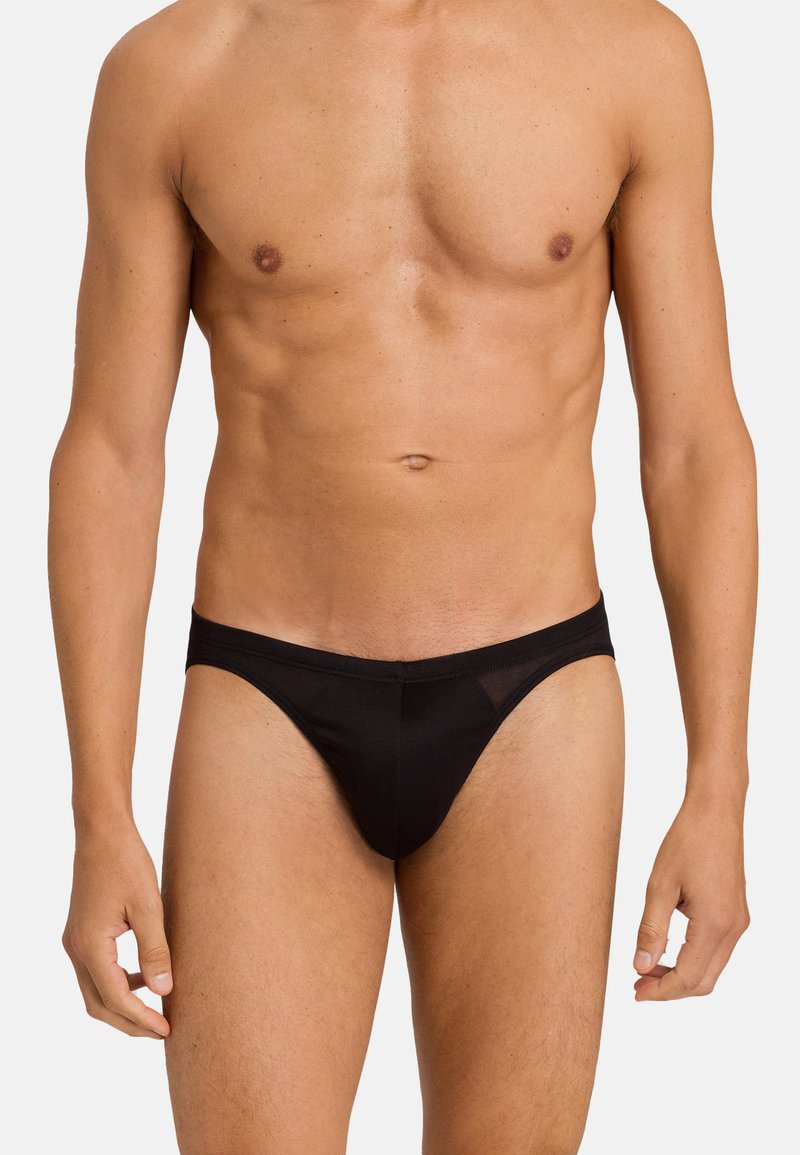 Schwarze Thong-Unterwäsche für Männer aus einem glatten Stoff, mit einer niedrig geschnittenen Taille und minimaler Bedeckung, entworfen für Komfort und Passform.