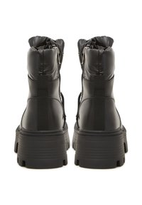 Botines negros con parte superior acolchada, suela de goma, cordones planos, cremallera lateral y un acabado texturizado en el material.