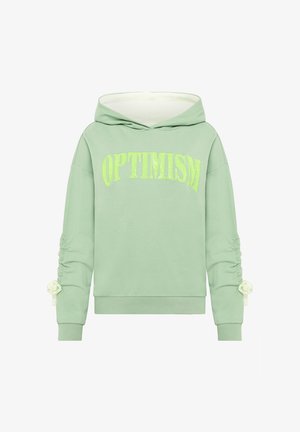 Groene sweatshirt met capuchon, met "OPTIMISME" in fel geel-groene tekst. Lange mouwen met geplooide details en lintaccenten.