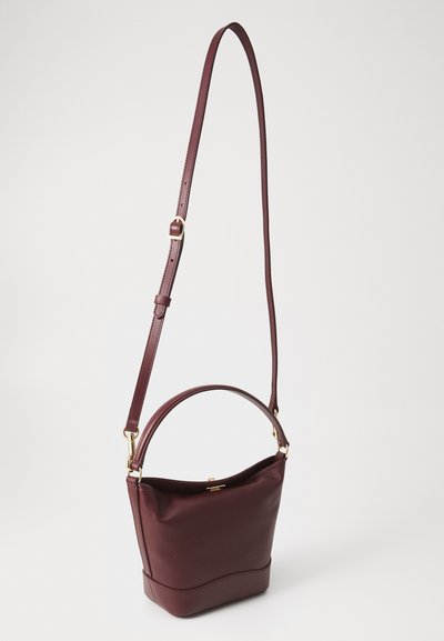 Borsa a mano in pelle color bordeaux con design strutturato. Presenta un manico superiore e una tracolla regolabile, dettagli in hardware dorato e una texture liscia.