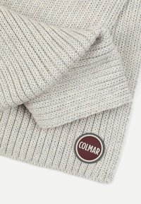 Lys grå strikket tørklæde med ribbet tekstur, der har et rundt Colmar-logo i bordeaux og hvidt i nederste højre hjørne.