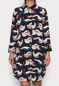 Schwarzes Kleid mit bunten, abstrakten Wellenmustern in Pink, Blau und Orange. Verfügt über einen Kragen, lange Ärmel und eine Knopfleiste.