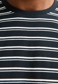 Zwart-wit gestreepte T-shirt met een ronde hals, gemaakt van zachte katoenstof; heeft gelijkmatig verdeelde horizontale strepen.