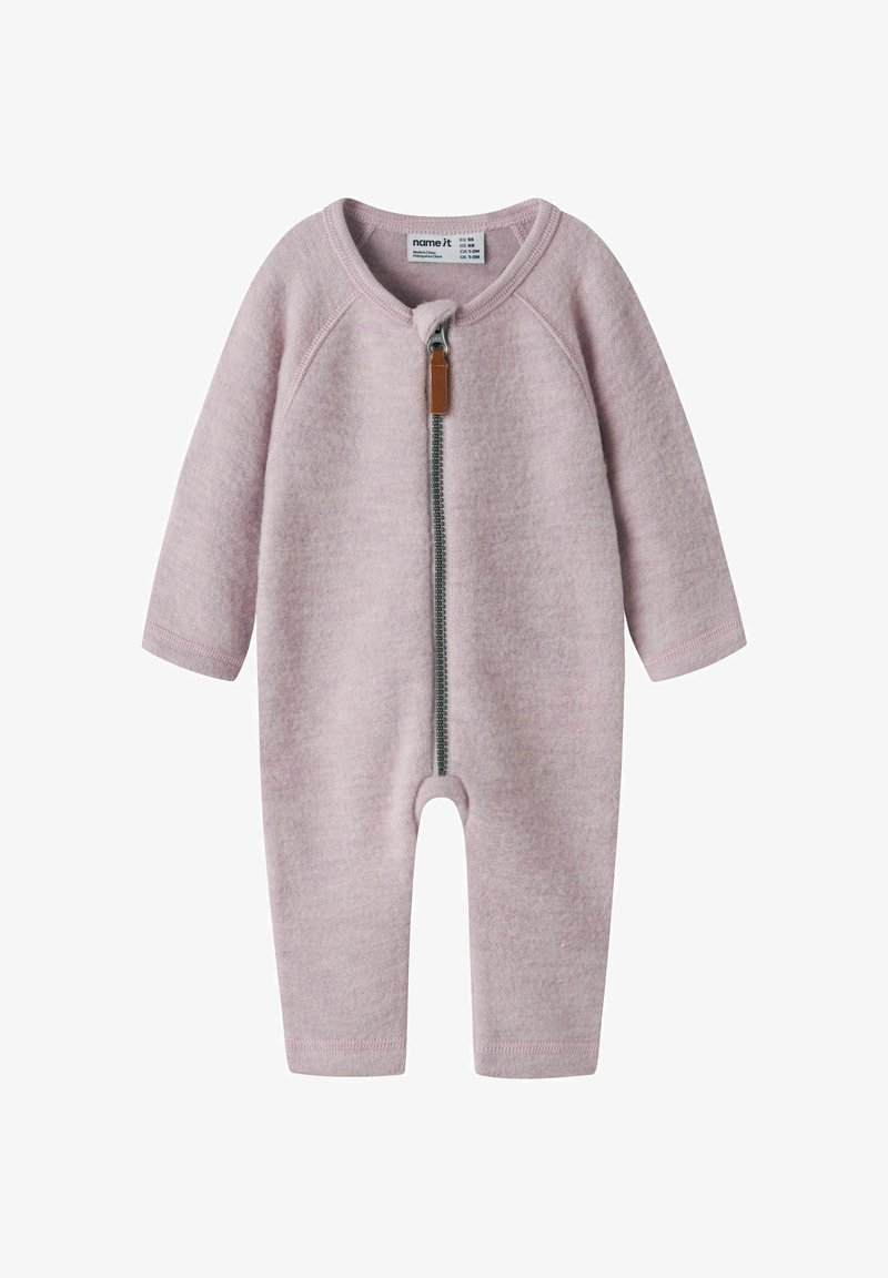 Grenouillère pour bébé rose clair en tissu doux, avec manches longues, une fermeture éclair à l'avant et une tirette en cuir marron.