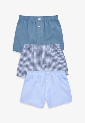 Drei Paar Boxershorts: eine einfarbige dunkelblaue, eine blau karierte und eine einfarbige hellblaue, jeweils mit einem elastischen Bund und einer vorderen Knopfleiste.