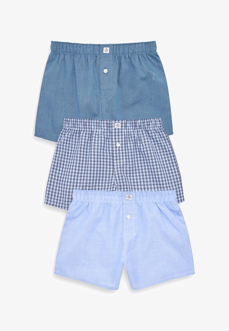 Drie paar boxershorts: één effen donkerblauw, één blauw met een geruit patroon, en één effen lichtblauw, elk met een elastische tailleband en een knoop aan de voorkant.
