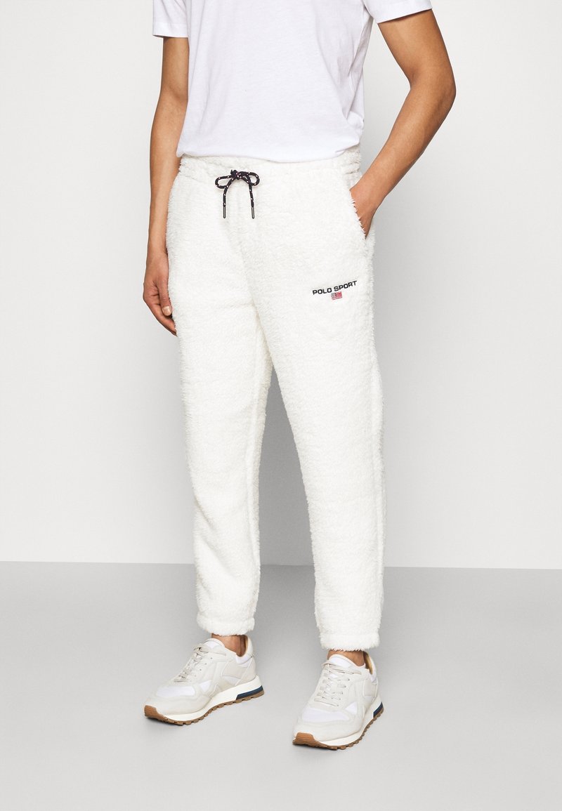 Vita, fluffiga fleece-joggers med elastisk midjeresår och dragsko, med "POLO SPORT"-logga i svart och rött på vänster lår.