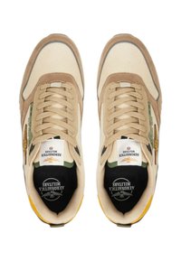 Sneakers beige con tomaia in tessuto, dettagli marroni, solette nere e rifiniture verdi. Presentano lacci bianchi e suola gialla.