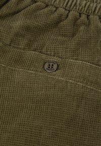 Olijfgroen corduroy stof met een kleine knop die gestikte details toont en een verzamelde elastische tailleband.