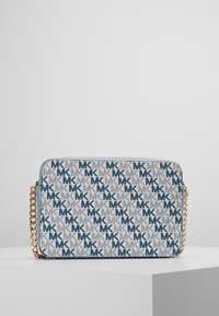 Borsa a tracolla beige con motivo logato blu MK. Caratterizzata da una catena dorata, forma rettangolare e superficie liscia.