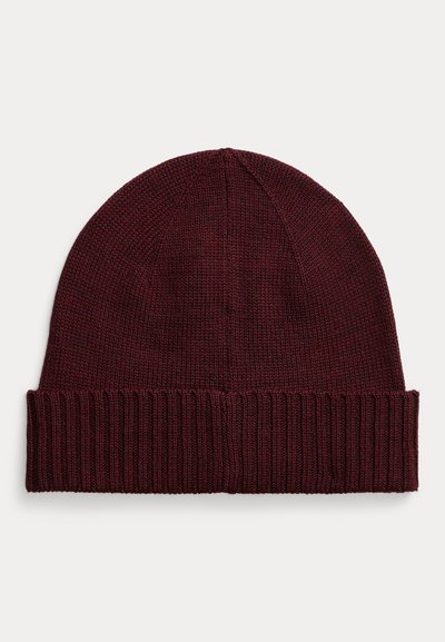 Burgundijas adīta beanie cepure ar ribotu maliņu, ar noapaļotu augšu un maigu tekstūru, piemērota ikdienišķai valkāšanai aukstā laikā.