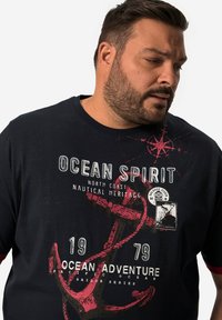 Námořnické bavlněné tričko s námořnickými grafikami, včetně kotvy, kompasového designu a textu "OCEAN SPIRIT" v bílé a červené barvě.
