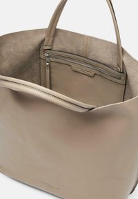 Beżowa skórzana torba na ramię o teksturowym wykończeniu, wyposażona w zamykaną kieszeń wewnętrzną oraz solidne uchwyty. Wnętrze ma miękką podszewkę.