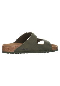 Green Birkenstock sandal with a cross-strapped design, cork footbed, textured upper, and rubber outsole. Features brand logo on side.