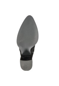 Chaussure à talons hauts en daim noir avec un bout pointu. La semelle présente un fond en caoutchouc gris texturé pour une meilleure adhérence. Accentuée d'un talon noir lisse.