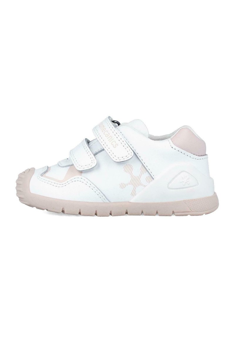 Zapatillas infantiles en blanco y rosa claro con dos correas de Velcro, suela de goma, punta redondeada y logo en relieve. Presenta un diseño texturizado en el lateral.
