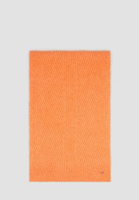 Pomarańczowy szal prążkowany o miękkiej fakturze, z delikatnym ukośnym wzorem oraz małym logo w dolnym prawym rogu.