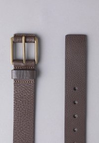 Brown leather belt with a textured finish, featuring a brass double-prong buckle and reinforced stitching, positioned flat against a neutral background.
