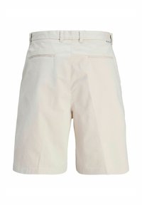 Beige bomulds shorts med flad foran, bæltestropper og to baglommer med lynlås. Glat tekstur og skræddersyet design.