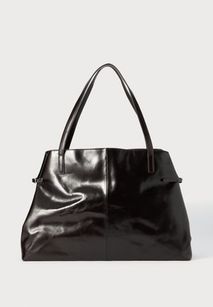 Sac fourre-tout en cuir noir avec texture lisse, deux longues poignées et des coutures subtilement visibles. Présente une large ouverture, idéale pour transporter des objets.