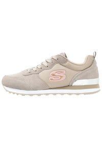 Sneaker beige chiaro in suede e rete. Presenta una parte superiore testurizzata, lacci frontali, accento del logo rosa e suola in gomma bianca con bordi grigi.