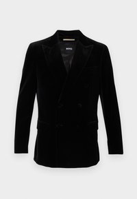 Blazer in velluto nero doppiopetto con rever a punta, polsini con bottoni e due tasche a soffietto frontali, etichetta "BOSS" all'interno del colletto.