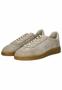 Beige Wildleder-Sneaker mit cremefarbenen Schnürsenkeln, runder Zehenpartie, strukturiertem Gummisohle und dezenter Markenkennzeichnung an der Seite. Minimalistisches Design mit einer glatten Zunge.