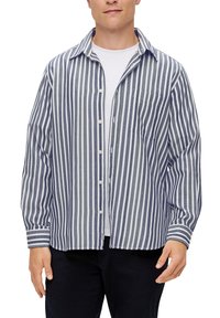 Casual overhemd met marineblauwe en witte verticale strepen, lange mouwen, een borstzak en lichte stof. Gedragen over een wit T-shirt.