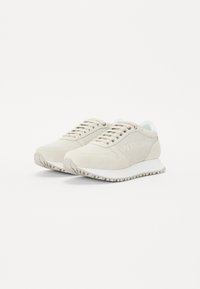 Beige sportieve schoenen van een mix van mesh en suede materialen, met een ronde neus, vetersluiting en textuurzolen voor grip.