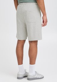 Szare szorty z mieszanki bawełny, z elastycznym paskiem w talii i tylną naszywaną kieszenią, o luźnym kroju i minimalistycznych detalach szwów.