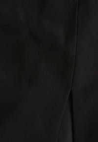 Černá látka s hladkou texturou, která má mírný lesk a detail s bočním rozparkem. Materiál vykazuje jemný diagonální tkaný vzor.