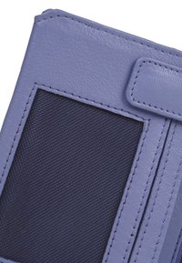 Portafoglio in pelle viola con un pannello in tessuto blu navy testurizzato, caratterizzato da dettagli di cucitura e una chiusura a pattina. Forma compatta per la portabilità.