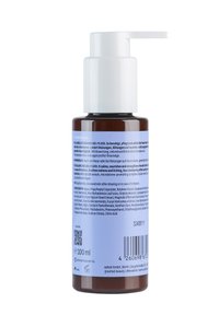 Bruine glazen fles met een witte pompd dispenser, voorzien van blauw-witte etiketten met informatie over het product en de ingrediënten. Capaciteit van 100 ml.