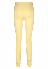 Gele legging met een hoge tailleband, een soepele textuur enGathered details bij de enkels. Ontworpen voor comfort en flexibiliteit.