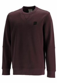 Felpa bordeaux realizzata in tessuto morbido, con collo rotondo, maniche lunghe, polsini e orlo a coste, e un piccolo dettaglio con logo a patch.