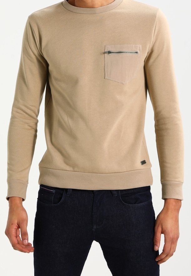 Felpa beige a maniche lunghe con scollo rotondo, tessuto strutturato, tasca sul petto con cerniera e polsini e orlo a costine.